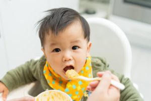 a baby beginning to eat solid food