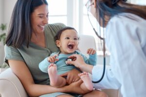 a doctor using a stethoscope to listen to a baby's heart