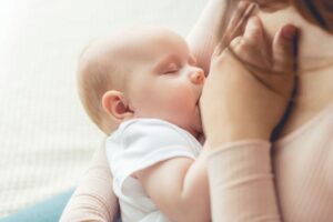 Mother holding her breastfeeding infant